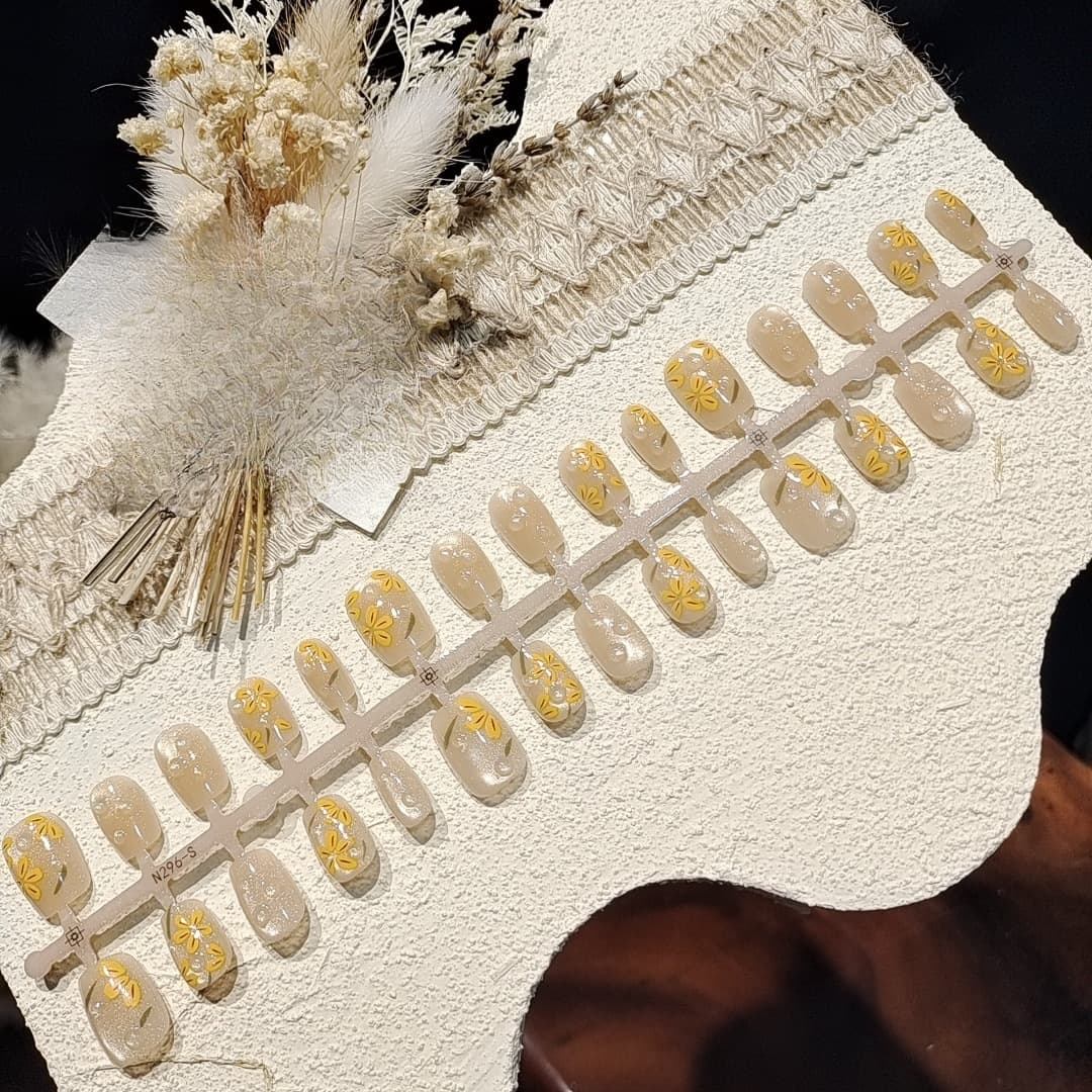 أظافر صناعية قصيرة بتصميم زهري برتقالي وتأثير عين القط